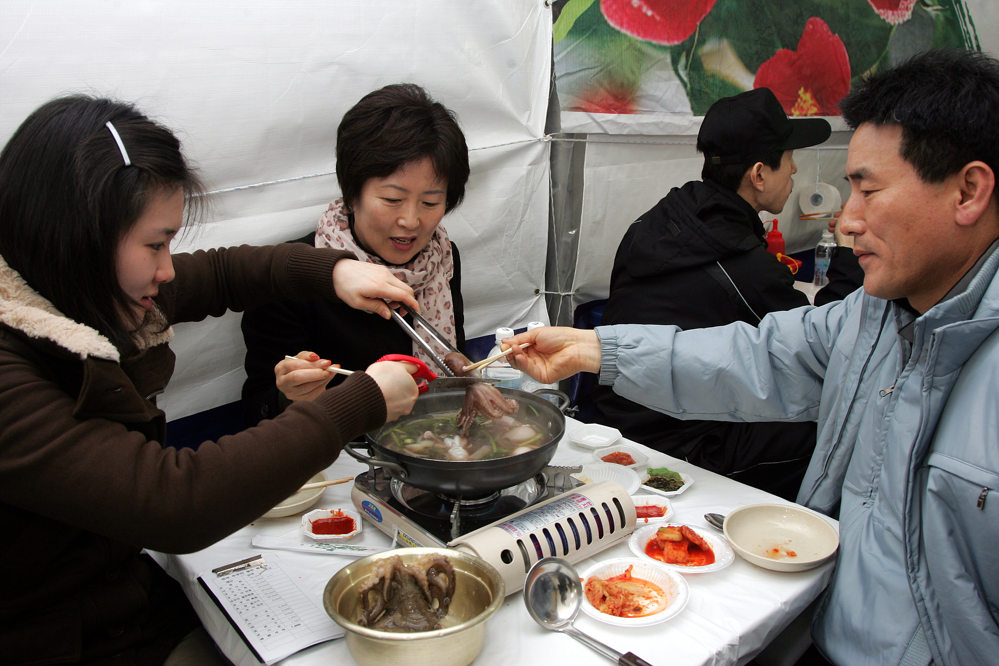 가족단위 관광객이 행사장을 찾아 주꾸미를 맛보고 있다